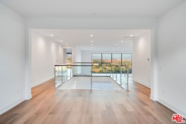 unfurnished room with expansive windows and light hardwood / wood-style floors