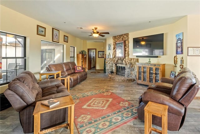 living room with a fireplace, hardwood / wood-style floors, and ceiling fan