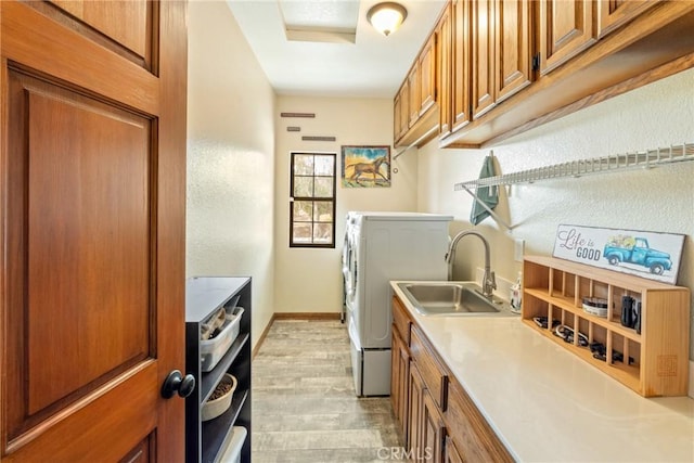 kitchen featuring light wood-type flooring, independent washer and dryer, and sink