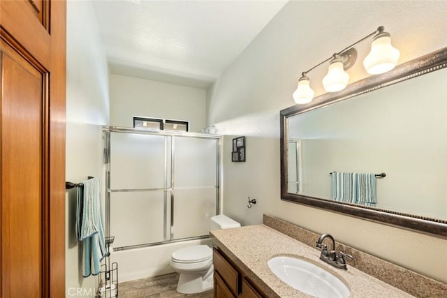 full bathroom featuring combined bath / shower with glass door, wood-type flooring, vanity, and toilet