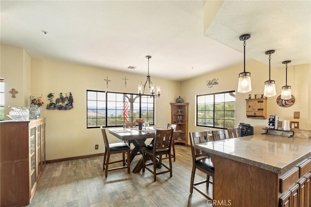 dining area with an inviting chandelier and hardwood / wood-style flooring