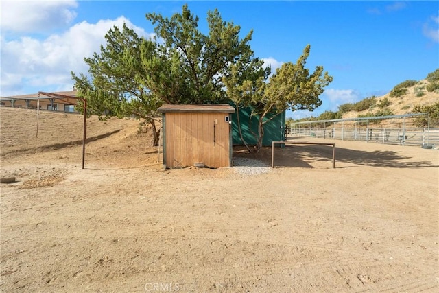 view of yard with an outbuilding and a rural view