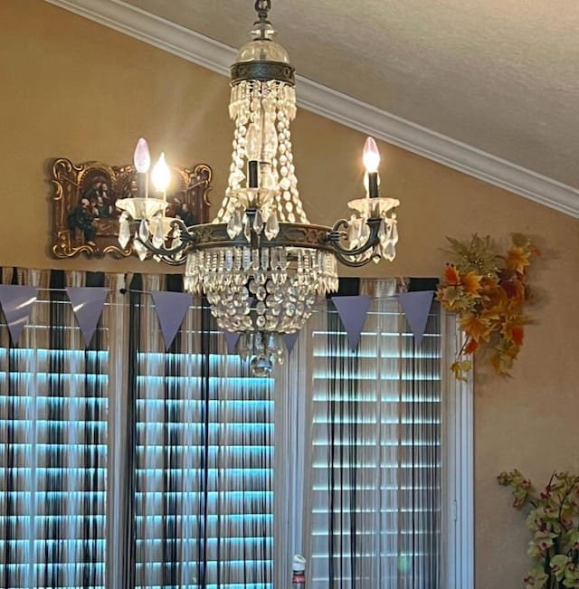 interior details with crown molding and a chandelier