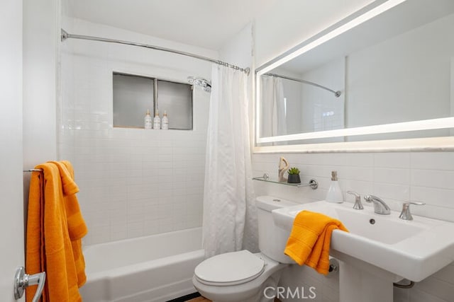 bathroom with backsplash, shower / bath combo, toilet, and tile walls