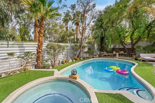 view of pool with an in ground hot tub and a yard