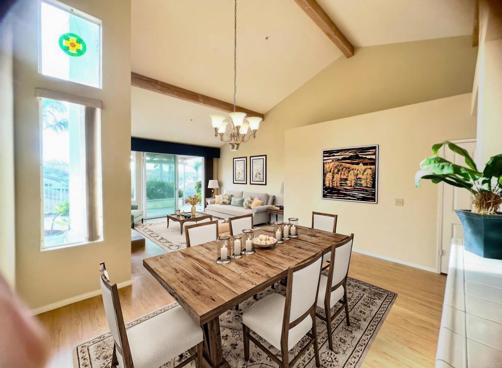 dining space featuring beam ceiling, a chandelier, high vaulted ceiling, light wood-type flooring, and baseboards