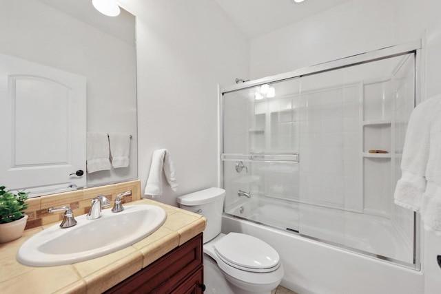 full bathroom featuring vanity, backsplash, toilet, and bath / shower combo with glass door