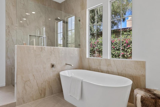 bathroom featuring tile patterned flooring, separate shower and tub, and tile walls