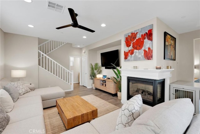 living room featuring wood-type flooring and ceiling fan