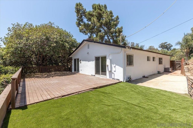 back of house with central AC unit, a lawn, and a patio