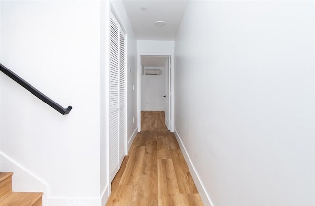 corridor featuring light hardwood / wood-style flooring and a wall mounted AC