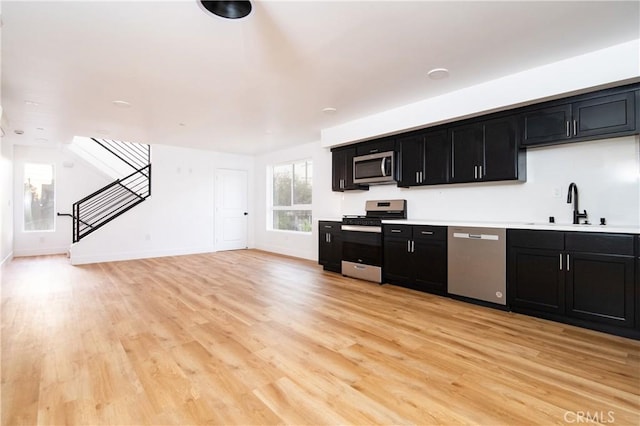 kitchen with sink, stainless steel appliances, and light wood-type flooring