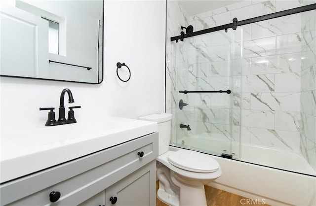 full bathroom with vanity, toilet, wood-type flooring, and bath / shower combo with glass door