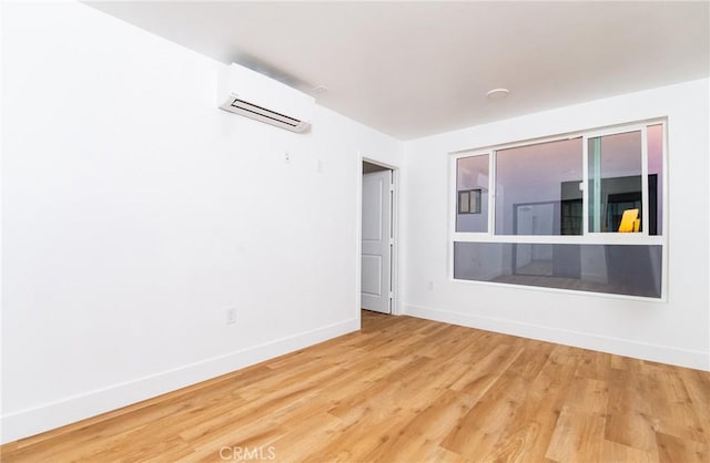 spare room featuring hardwood / wood-style flooring and a wall mounted AC