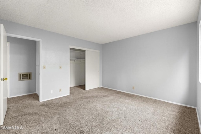 unfurnished bedroom with a textured ceiling, a closet, and carpet floors