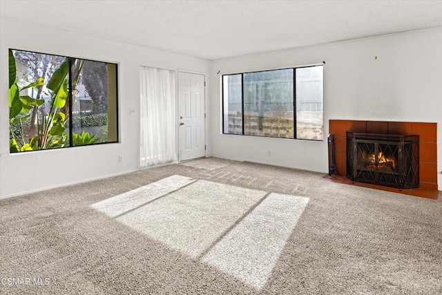 unfurnished living room featuring carpet and a tile fireplace