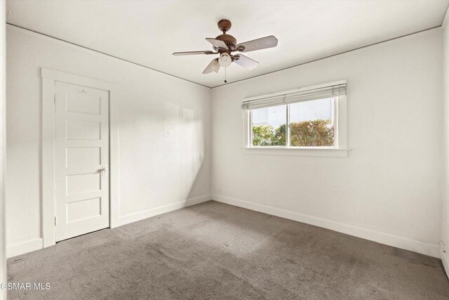 unfurnished room with ceiling fan and carpet