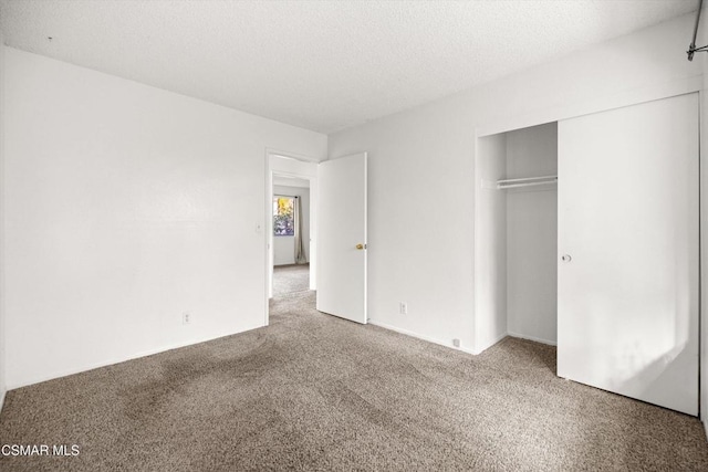 unfurnished bedroom featuring a closet, a textured ceiling, and carpet flooring