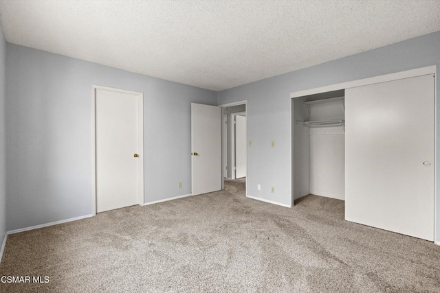 unfurnished bedroom with light colored carpet, a closet, and a textured ceiling