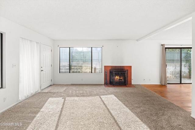 unfurnished living room with carpet floors and a tiled fireplace