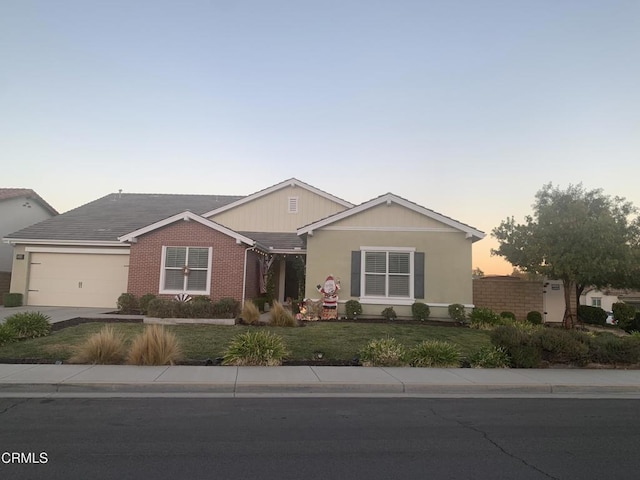 ranch-style home featuring a garage and a lawn