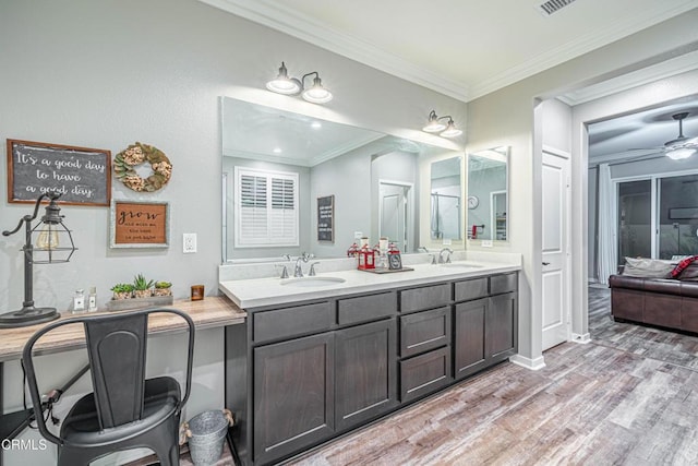 bathroom with ceiling fan, ornamental molding, wood-type flooring, and vanity