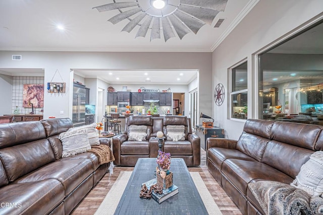 living room with crown molding and light wood-type flooring