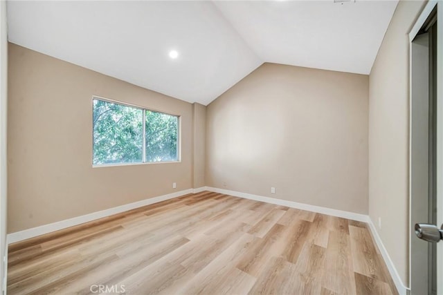 unfurnished room with light wood-type flooring and lofted ceiling