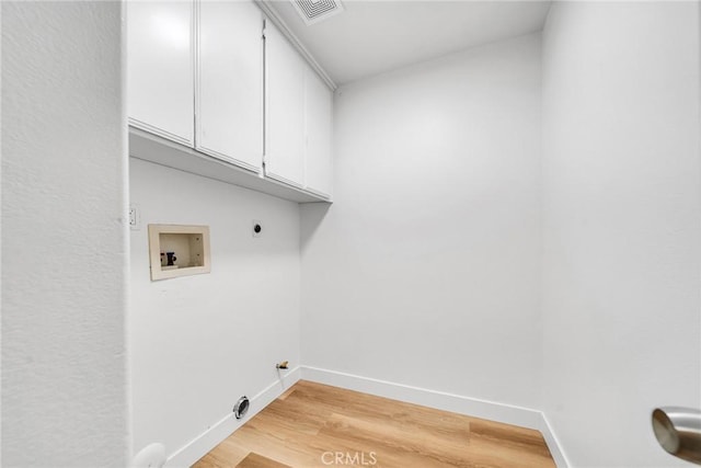 washroom featuring hookup for a washing machine, light hardwood / wood-style flooring, cabinets, and hookup for an electric dryer