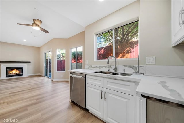 kitchen with stainless steel dishwasher, ceiling fan, sink, white cabinets, and light hardwood / wood-style floors