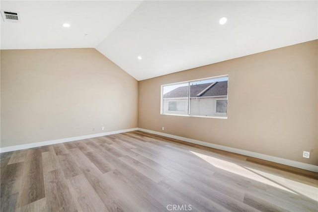 unfurnished room with light hardwood / wood-style flooring and lofted ceiling