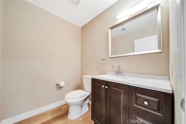 bathroom with vanity, hardwood / wood-style flooring, and toilet