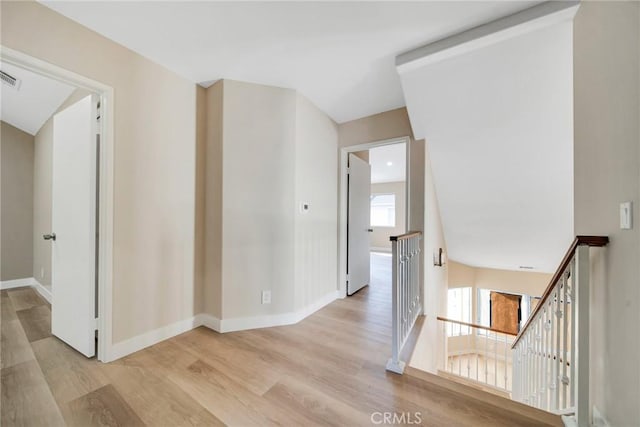 corridor with light hardwood / wood-style flooring and plenty of natural light