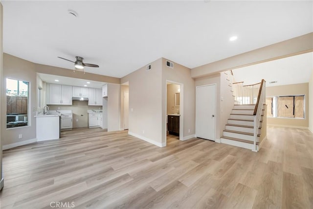 unfurnished living room featuring light hardwood / wood-style flooring, plenty of natural light, and ceiling fan