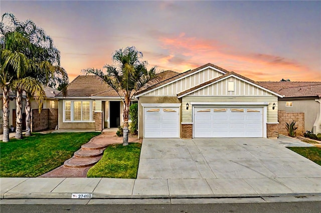 view of front of home with a garage and a yard