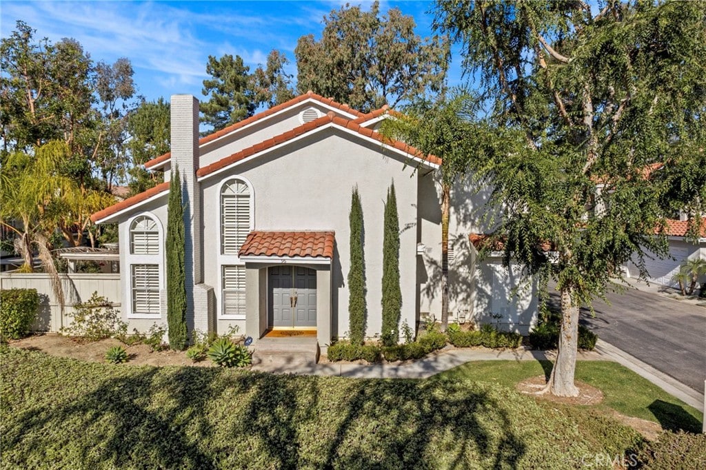 mediterranean / spanish-style home featuring a front lawn and french doors