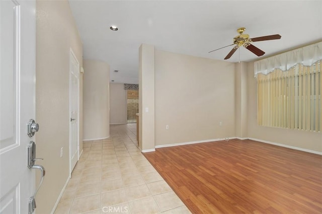 empty room with ceiling fan and light hardwood / wood-style flooring