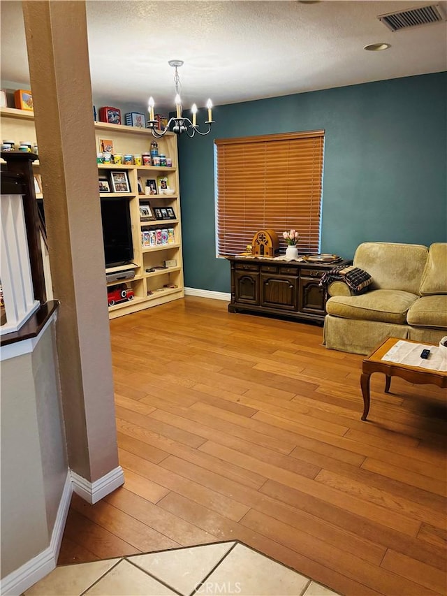 sitting room featuring light wood-type flooring and an inviting chandelier