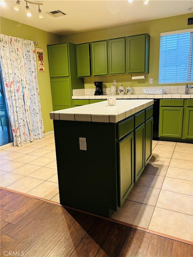 kitchen with a center island, tile counters, and green cabinetry