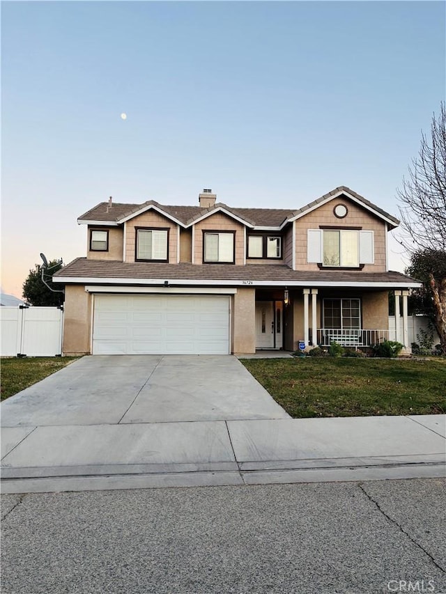 view of front of property with a porch, a yard, and a garage