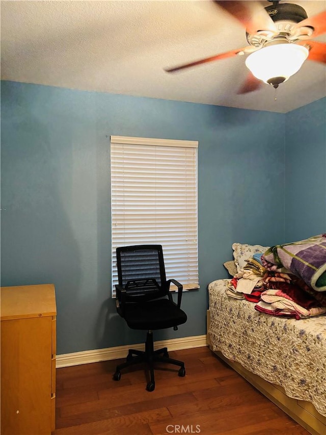 bedroom with ceiling fan, hardwood / wood-style floors, and a textured ceiling