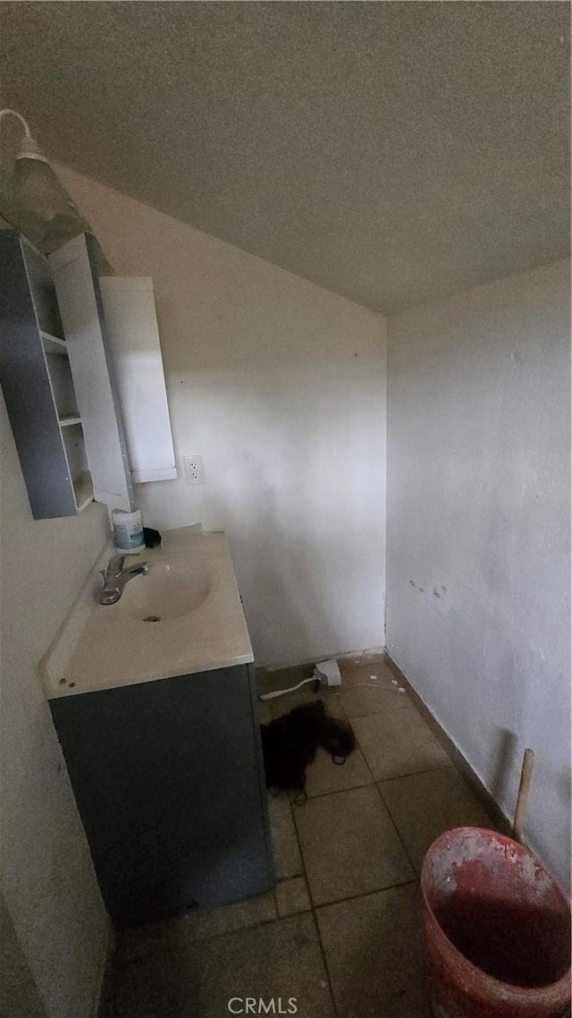 bathroom featuring tile patterned floors, vanity, and a textured ceiling