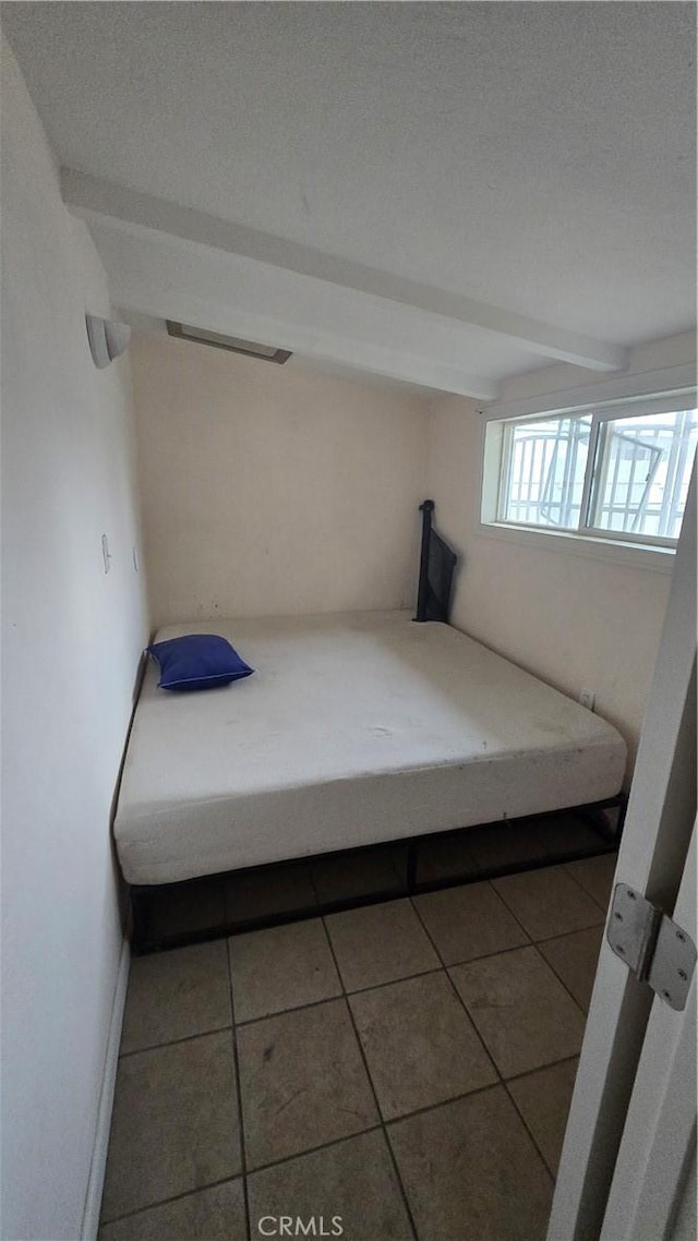 unfurnished bedroom with a textured ceiling and tile patterned floors