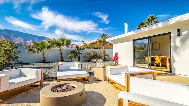 view of patio / terrace featuring a mountain view and an outdoor living space with a fire pit