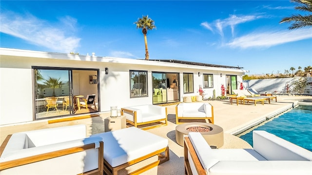 rear view of house featuring an outdoor living space with a fire pit and a patio area