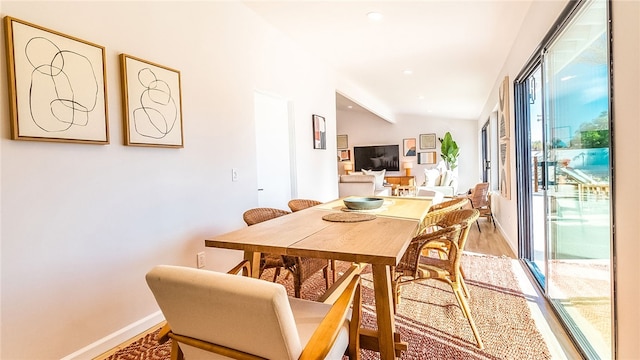 dining area featuring hardwood / wood-style floors and lofted ceiling