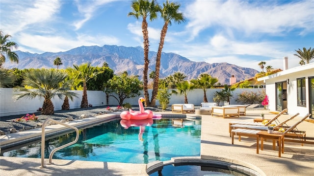 view of swimming pool with a patio area, an in ground hot tub, and a mountain view