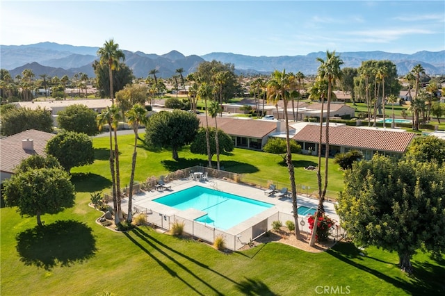 view of pool with a mountain view, a lawn, and a patio