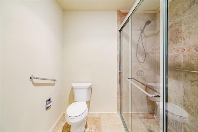 bathroom featuring toilet and a shower with door