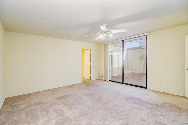 carpeted spare room with ceiling fan and floor to ceiling windows